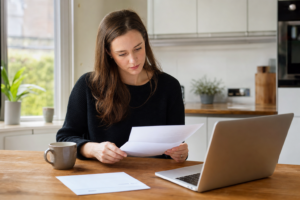 Person reviewing a rental tenancy agreement with court documents on a desk in England